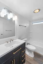 Full bath featuring vanity, light wood-type flooring, and shower / washtub combination