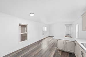 Unfurnished living room featuring lofted ceiling and dark wood finished floors