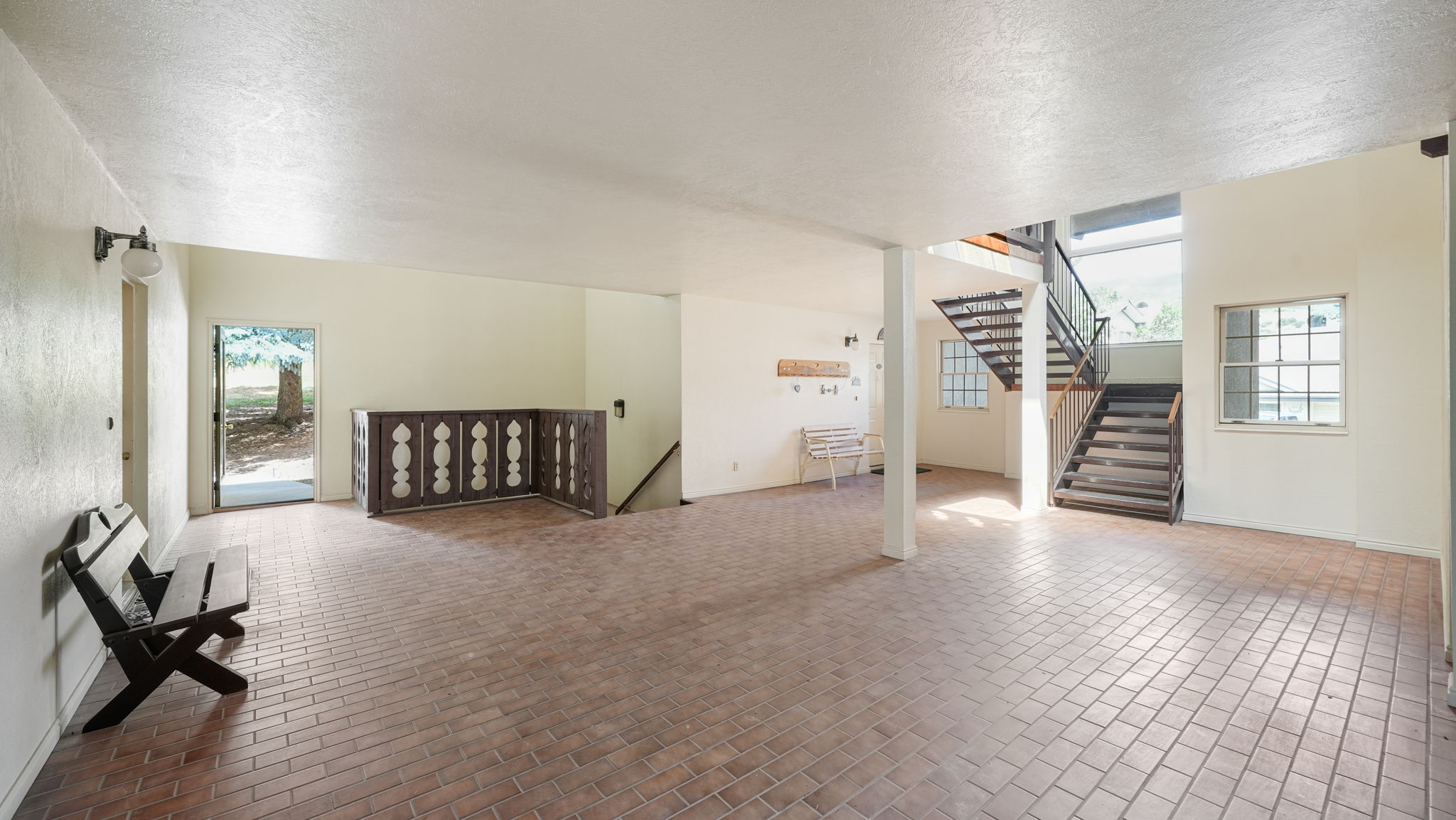 Additional living space with a textured ceiling and brick patterned floors