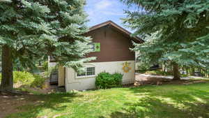 View of property exterior with a yard and stucco siding