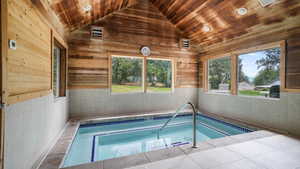 View of pool featuring a hot tub, a sunroom, and a swimming pool