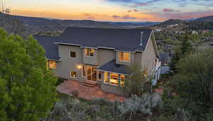 Rear view of property featuring stucco siding, a mountain view, and a patio