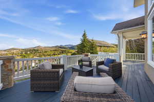 Wooden deck featuring outdoor seating and a mountain view