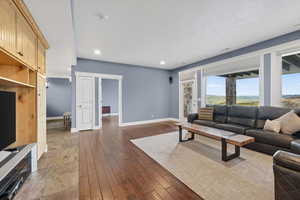 Living area with wood-type flooring and recessed lighting
