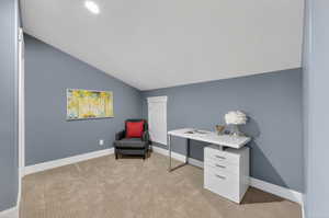 Office with light carpet and lofted ceiling
