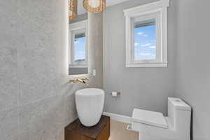 Bathroom featuring tile walls, vanity, and light tile patterned flooring