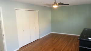 Unfurnished bedroom featuring dark wood finished floors, ceiling fan, and a closet