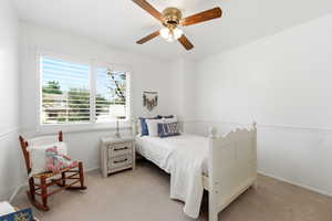 Bedroom featuring a ceiling fan and light carpet