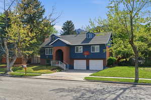 .24 acre, corner lot, Front view of lawn, driveway, a garage, and brick siding
