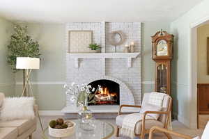 Sitting room with a brick fireplace and baseboards