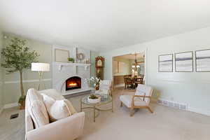 Living area featuring a fireplace, and light carpet