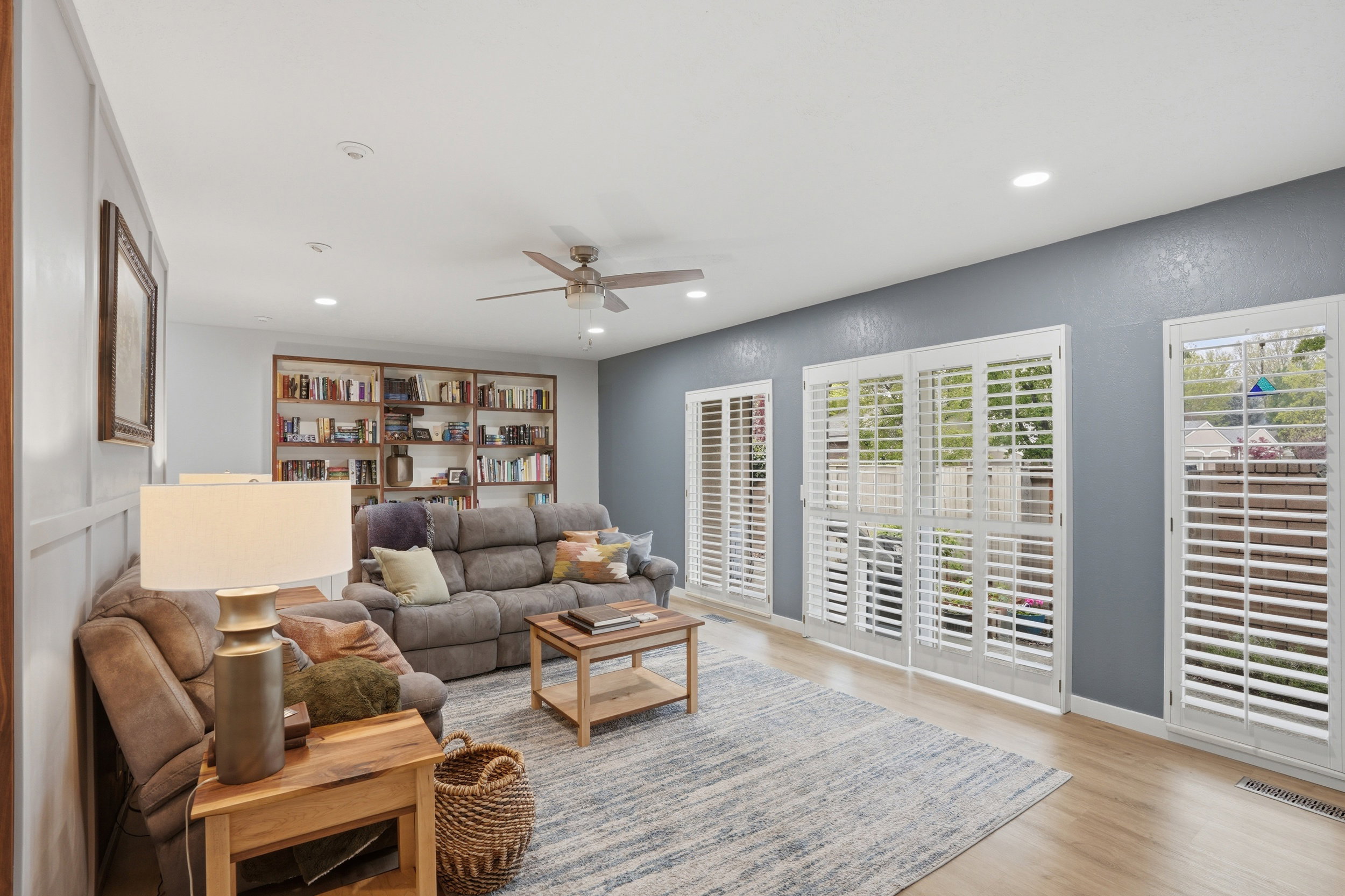 Living area with ceiling fan, light wood finished floors, and recessed lighting