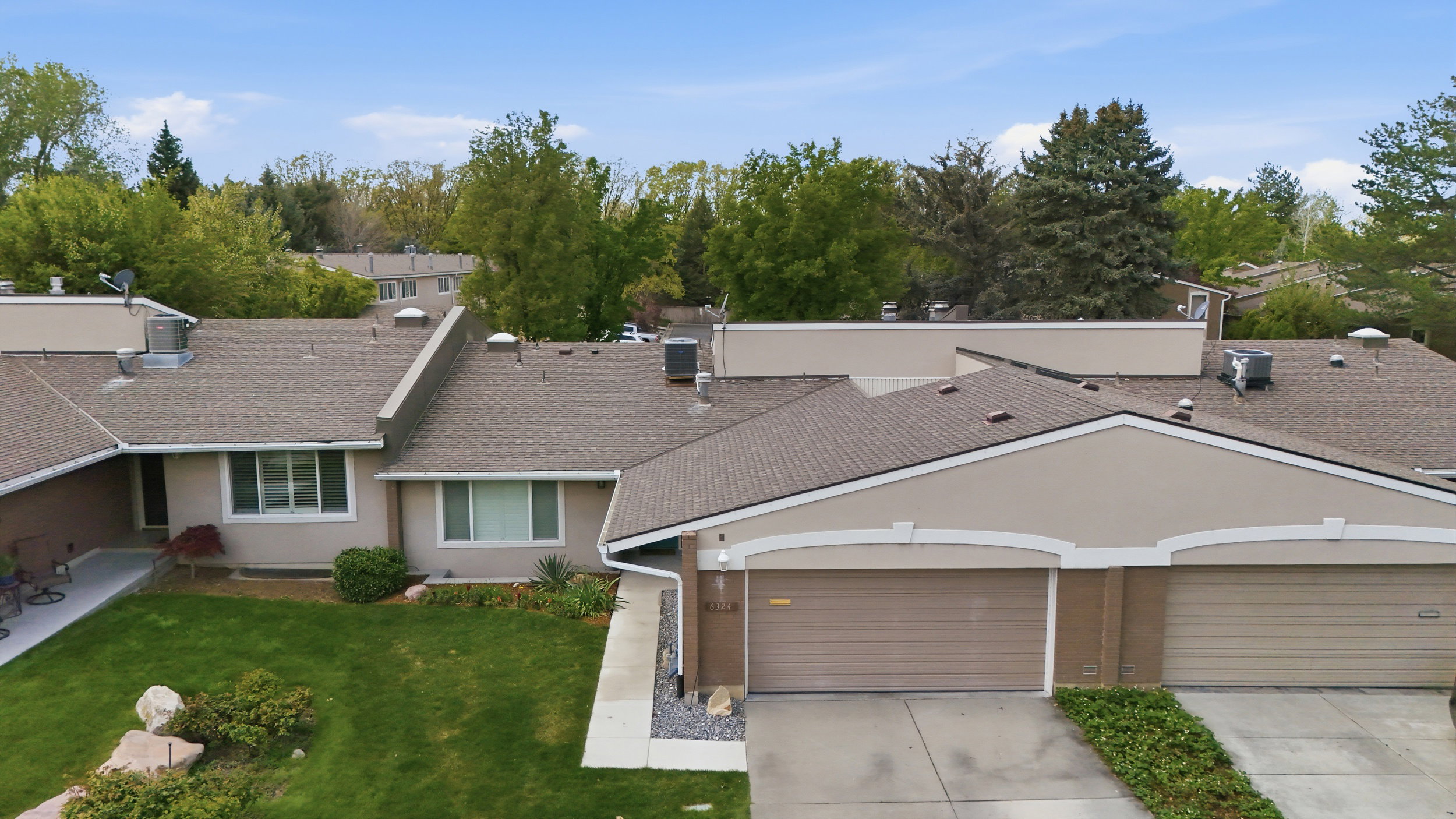 View of front of property featuring concrete driveway, an attached garage, a front yard, a shingled roof, and stucco siding