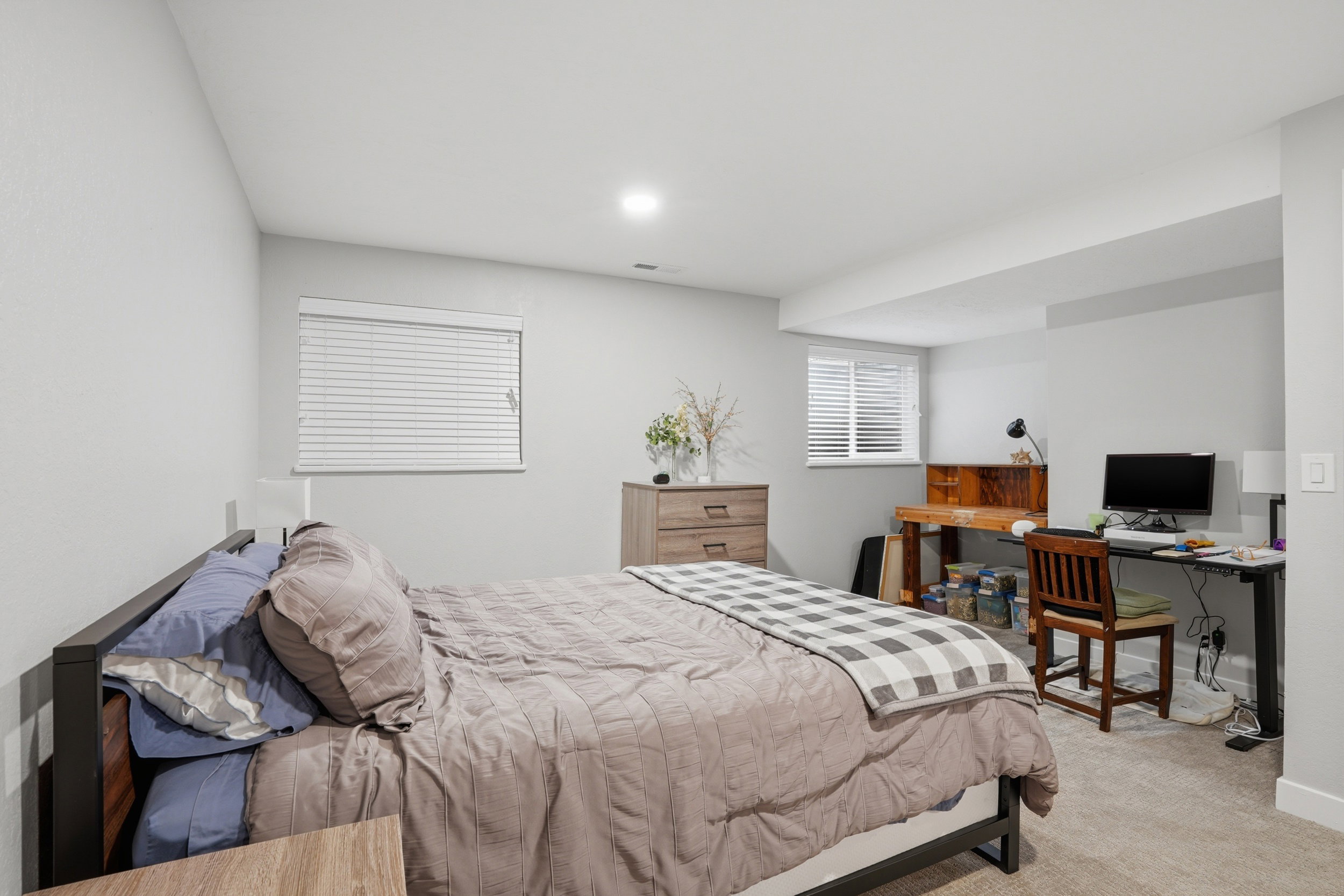 Bedroom with light carpet and a desk