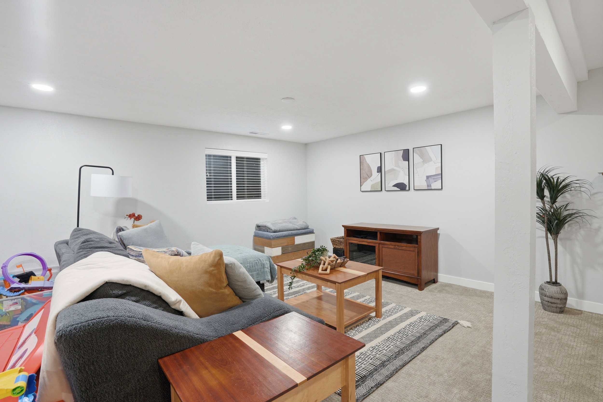 Living area with light colored carpet and recessed lighting