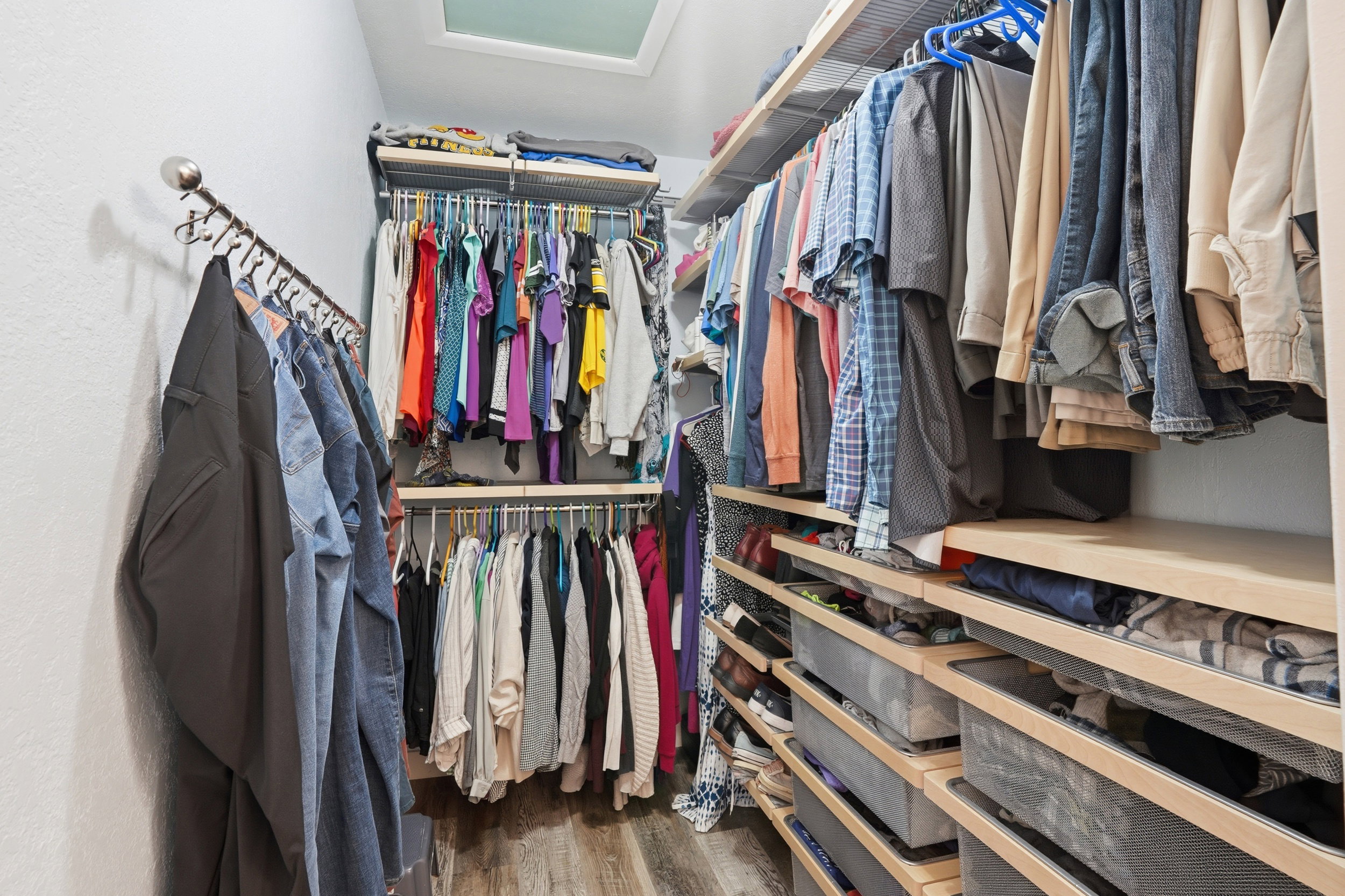 Walk in closet with attic access and dark wood-style floors