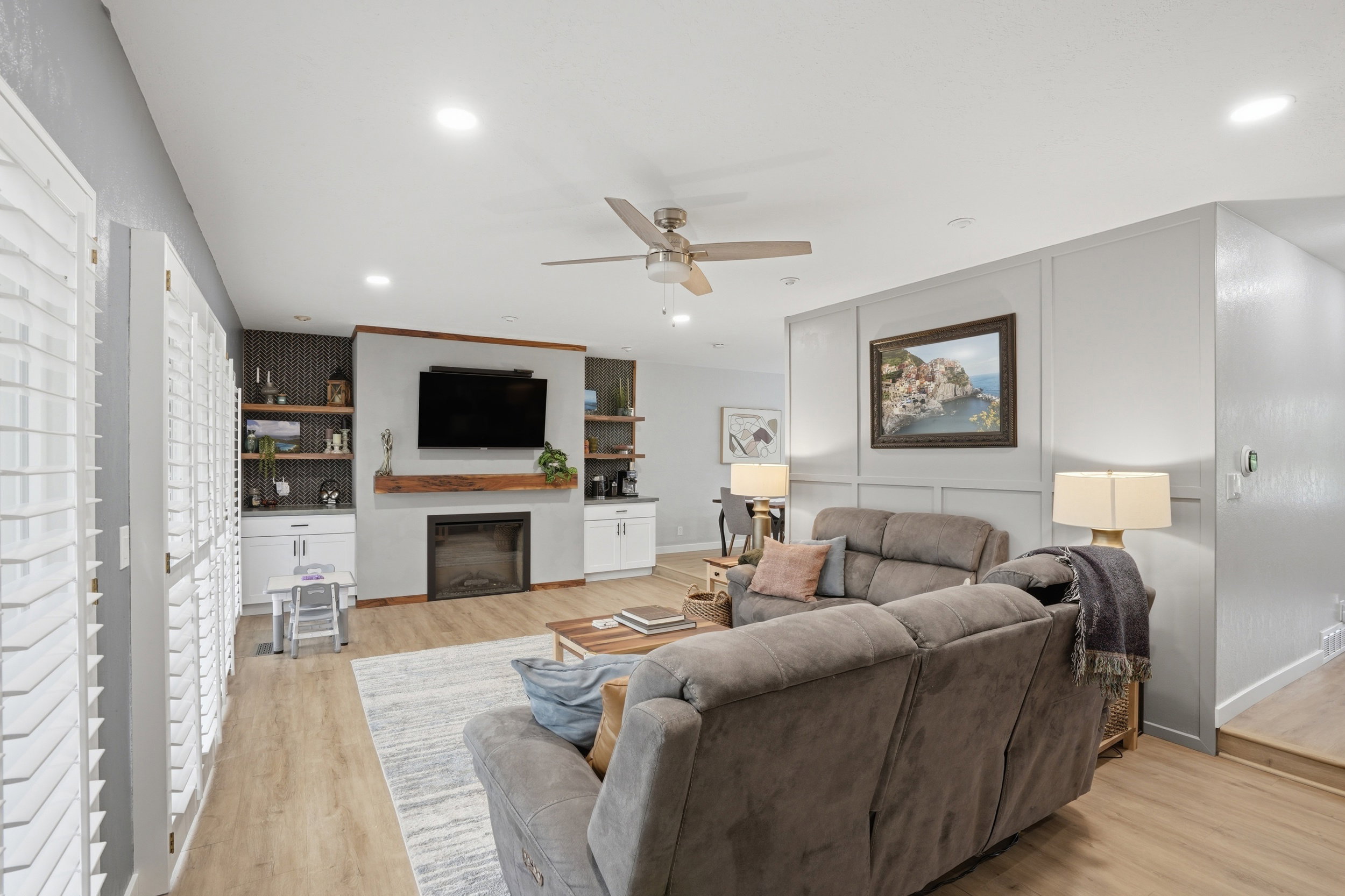 Living area featuring a ceiling fan, light wood-type flooring, recessed lighting, and a glass covered fireplace