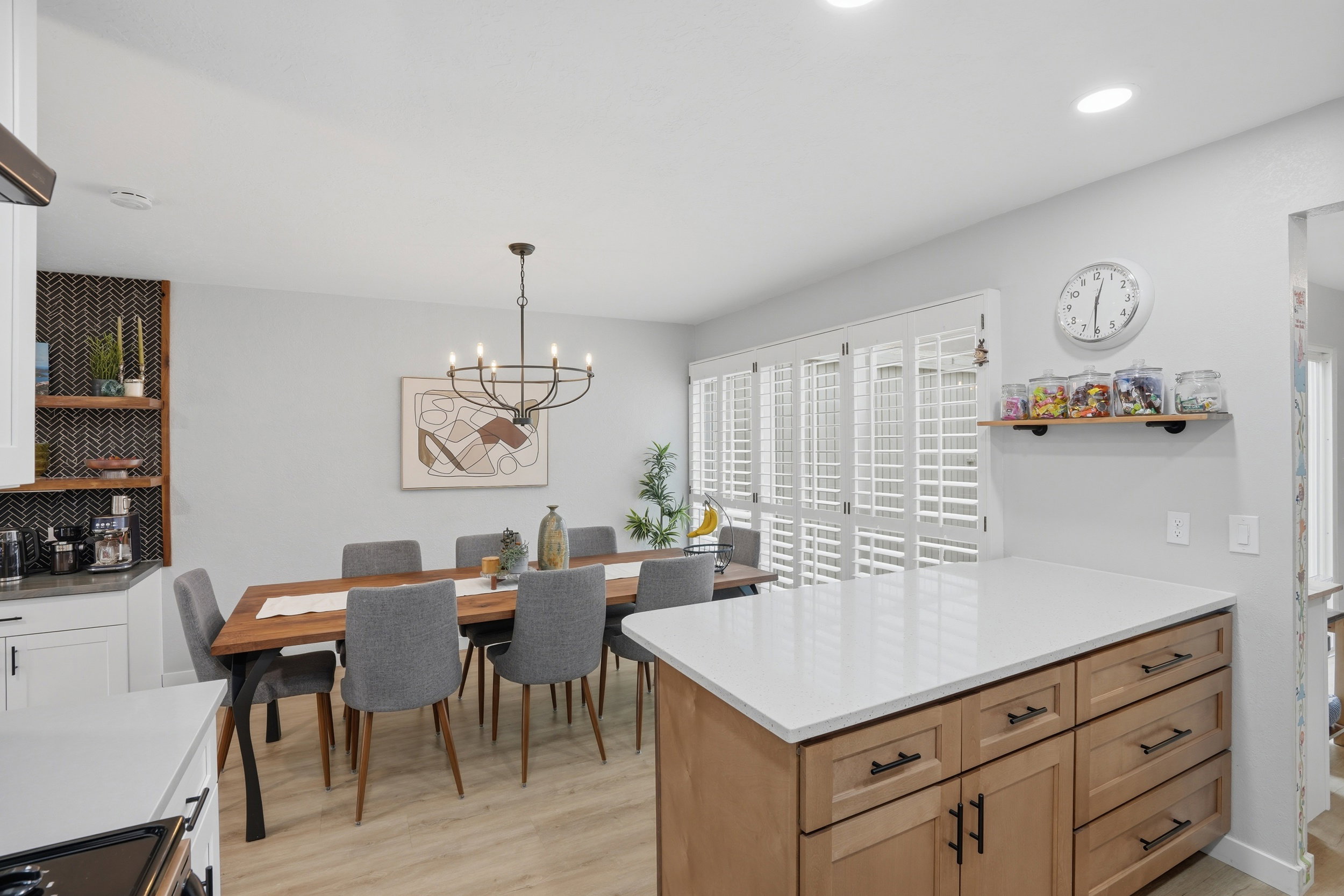Kitchen featuring a peninsula, open shelves, light wood-style flooring, a chandelier, and light wood finish cabinets