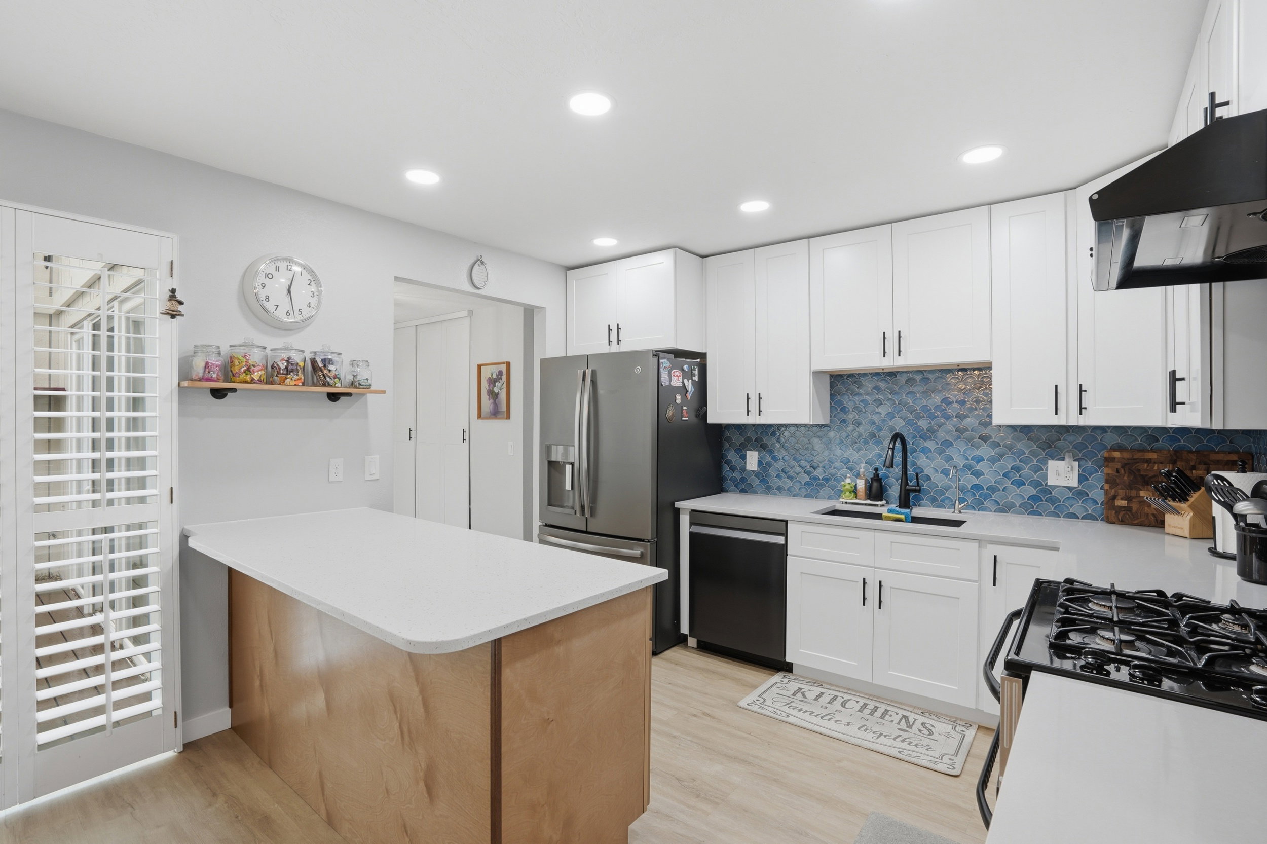 Kitchen featuring white cabinetry, a peninsula, light wood-style flooring, stainless steel appliances, and recessed lighting