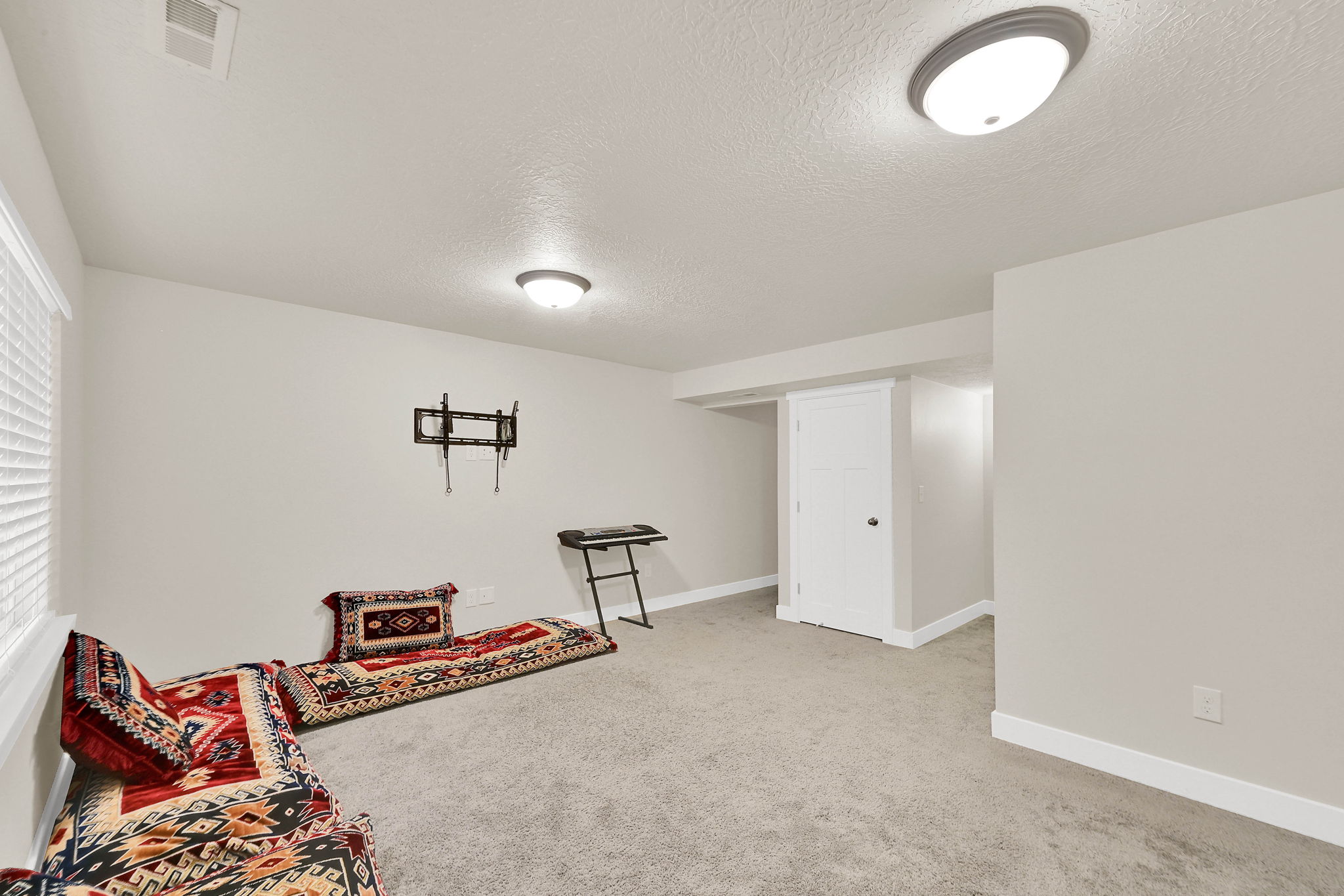 Living area featuring light carpet and a textured ceiling