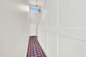 Hall with wood finished floors and a high ceiling