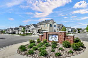 Community / neighborhood sign featuring a residential view