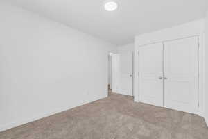 Unfurnished bedroom with carpet floors and a closet