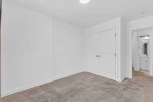 Unfurnished bedroom featuring carpet and a closet