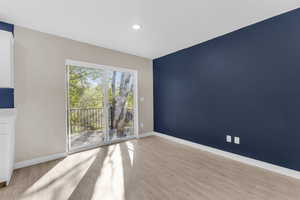 Empty room featuring light wood finished floors and recessed lighting