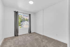 Carpeted spare room with baseboards