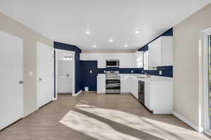 Kitchen featuring light countertops, stainless steel appliances, white cabinetry, and recessed lighting