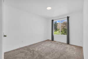 Spare room with carpet and baseboards