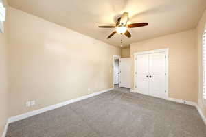 Unfurnished bedroom featuring carpet flooring, a closet, and ceiling fan