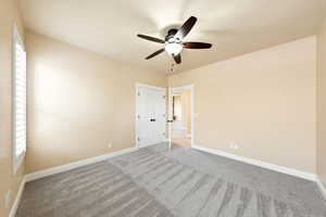 Unfurnished bedroom with a ceiling fan and light colored carpet