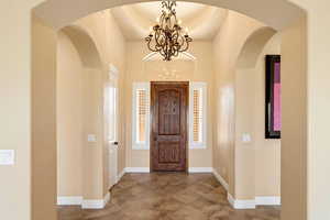 Foyer entrance with baseboards and hanging lights