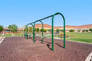 Communal playground featuring a mountain view and a lawn