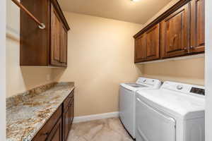 Laundry room with cabinet space, washing machine and dryer, and a textured ceiling