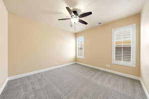 Empty room featuring light colored carpet and a ceiling fan