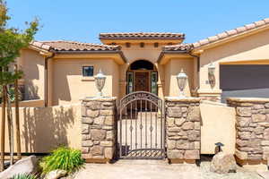 Mediterranean / spanish-style home with a gate, a fenced front yard, stucco siding, and a tiled roof