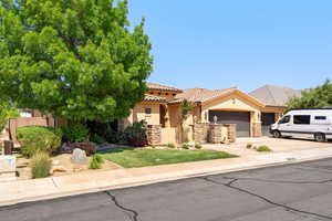 View of front of house featuring stone siding, an attached garage, stucco siding, a tiled roof, and driveway