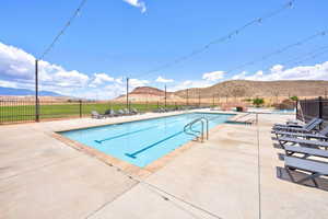 Community pool with a mountain view and a patio area