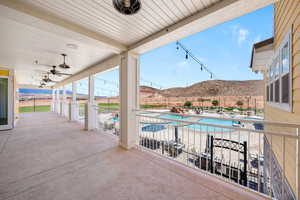 View of patio with a community pool, a mountain view, and a ceiling fan