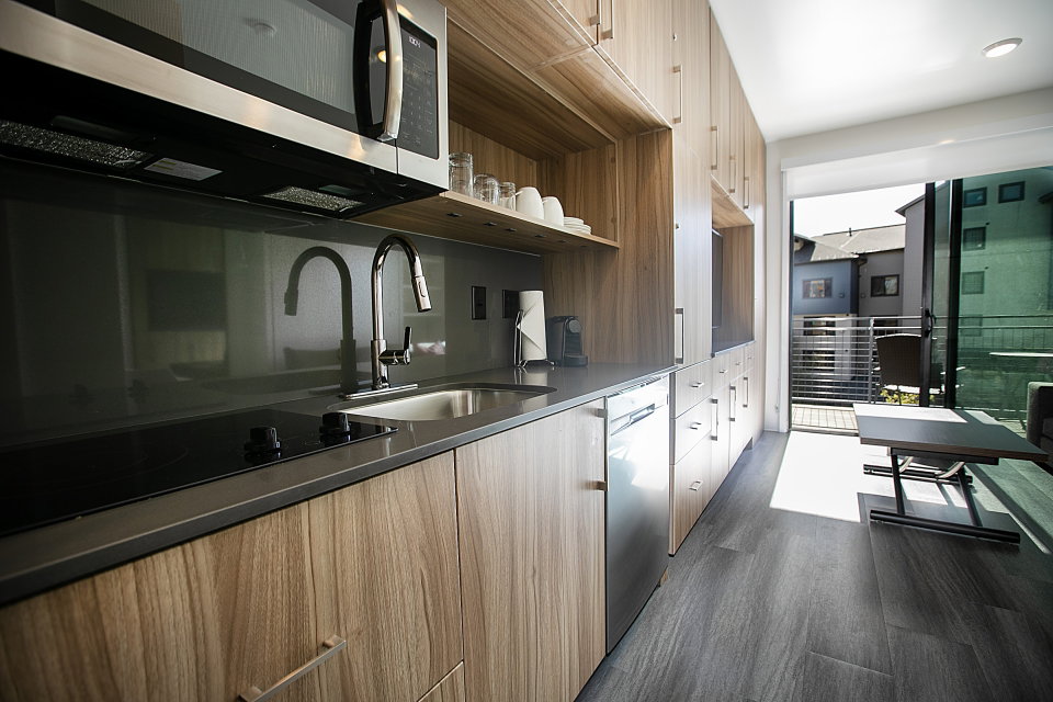 Kitchen featuring stainless steel appliances, modern cabinets, open shelves, and dark wood finished floors