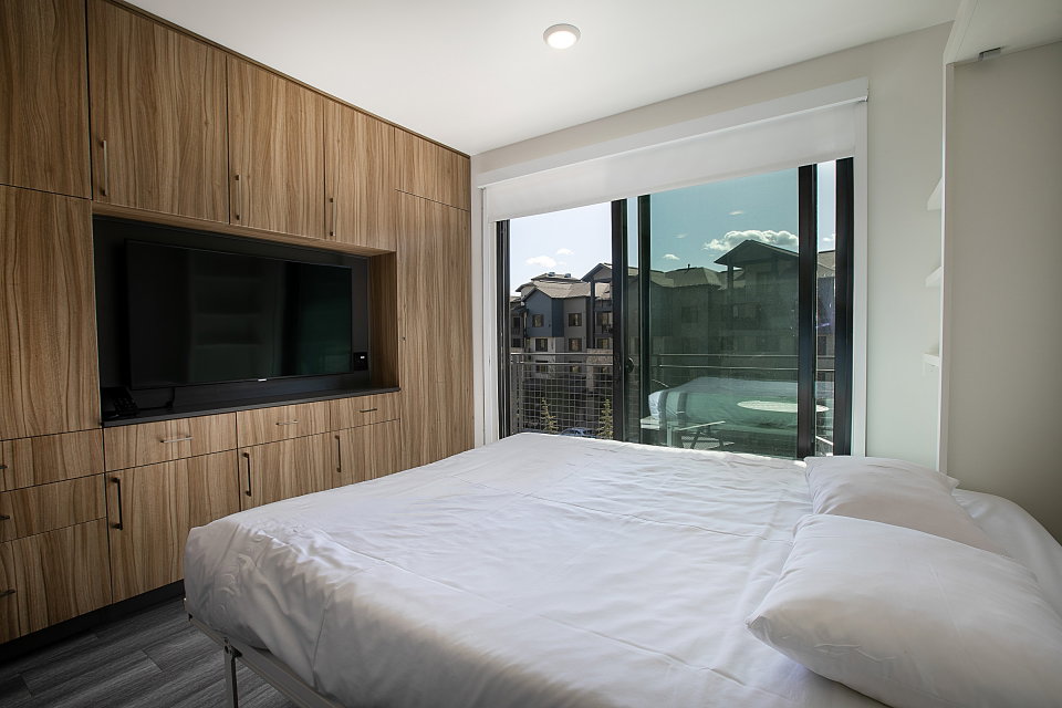 Bedroom with access to exterior and dark wood-style floors