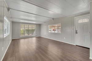 Entrance foyer featuring dark wood-style flooring and vaulted ceiling with beams