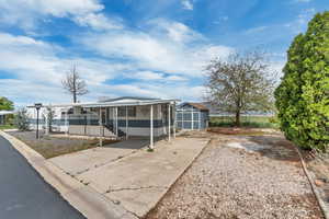 Manufactured / mobile home featuring a shed, concrete driveway, and a porch