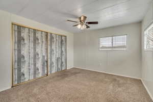 Carpeted spare room featuring ceiling fan