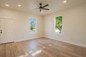 Spare room with light wood-style floors, ceiling fan, and recessed lighting