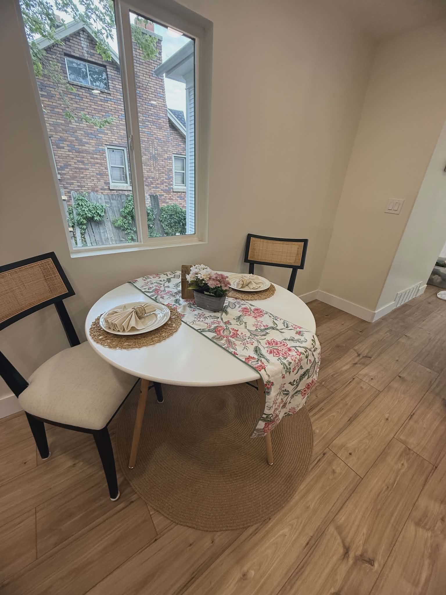 Dining area featuring wood-finish flooring, a contemporary window, and neutral wall paint