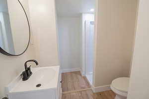Full bathroom with vanity, light wood finished floors, and recessed lighting